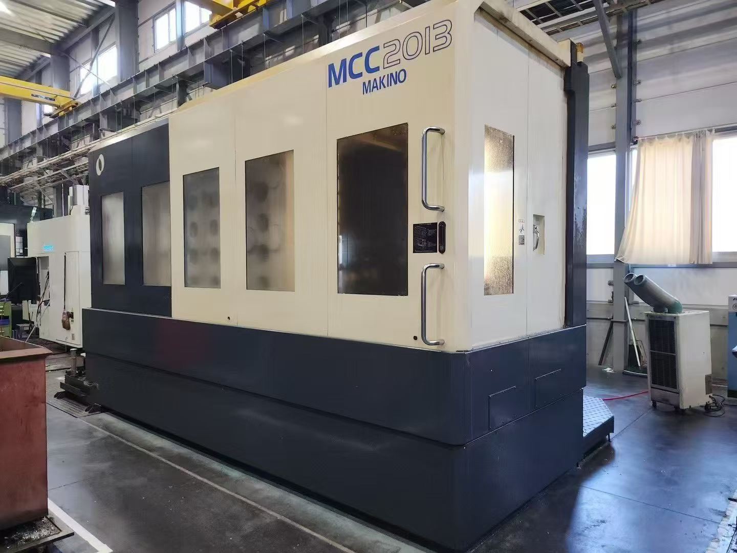日本牧野MCC2013加工中心是高效模具加工的全面集合，具有在单一设置中实现多面加工的功能，
标准规格：这些功能包括高速15000 min-1主轴，16m/min切削进给率，高速，高精度GI.3控制和热稳定系统。MCC还采用半浮动导轨系统，即使工作台上的工件很重，也能提供16m/min的切削进给速度。0.1μm GI.3控制的采用大大提高了加工精度和加工表面质量。
操作系统：Professional 5
工作台面：2200 x 1000 mm
X 轴：2000 mm Y 轴：1350 mm Z 轴：1000 mm（三轴带光棚尺）
主轴鼻端至工作台端面的距离：-100～900 mm
工作台上面至主轴中心的距离：75～1425mm
主轴：15,000 prm （带中心出水）
主轴刀柄型号：HSK-A100
X、Y、Z轴快移速度：16000 mm/min
切削速度：16000 mm/min
最大工件：2500 x 1100 x 1700 mm
最大承载重量：10,000 kg
刀库容量：30把
无条件可收纳刀具最大直径：φ125 mm
邻接刀具受限制时可收纳刀具最大直径：φ200 mm
刀具最大长度：550 mm
刀具最大重量：20 kg
机械重量：约21,000 kg