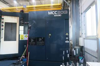 日本牧野MCC2013加工中心是高效模具加工的全面集合，具有在单一设置中实现多面加工的功能，
标准规格：这些功能包括高速15000 min-1主轴，16m/min切削进给率，高速，高精度GI.3控制和热稳定系统。MCC还采用半浮动导轨系统，即使工作台上的工件很重，也能提供16m/min的切削进给速度。0.1μm GI.3控制的采用大大提高了加工精度和加工表面质量。
操作系统：Professional 5
工作台面：2200 x 1000 mm
X 轴：2000 mm Y 轴：1350 mm Z 轴：1000 mm（三轴带光棚尺）
主轴鼻端至工作台端面的距离：-100～900 mm
工作台上面至主轴中心的距离：75～1425mm
主轴：15,000 prm （带中心出水）
主轴刀柄型号：HSK-A100
X、Y、Z轴快移速度：16000 mm/min
切削速度：16000 mm/min
最大工件：2500 x 1100 x 1700 mm
最大承载重量：10,000 kg
刀库容量：30把
无条件可收纳刀具最大直径：φ125 mm
邻接刀具受限制时可收纳刀具最大直径：φ200 mm
刀具最大长度：550 mm
刀具最大重量：20 kg
机械重量：约21,000 kg-3